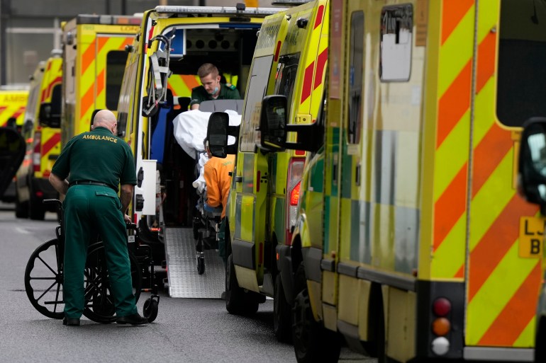 A patient is taken in to an ambulance as other ambulances wait outside the Royal London Hospital in east London