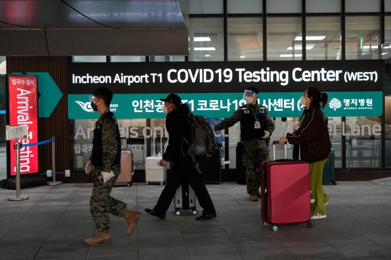 Passengers arriving from China pass by a COVID-19 testing centre at the Incheon International Airport in Incheon, South Korea.