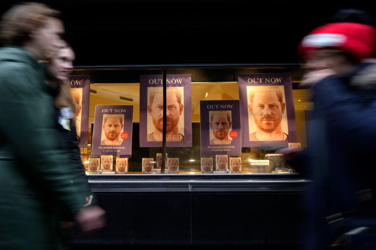 Pedestrians pass a display in the window of a book shop in London, the United Kingdom, where Prince Harry's book is prominently displayed.