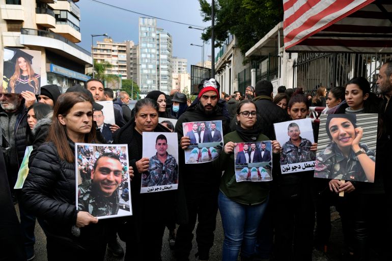 Protesters hold photos of victims of beirut blast