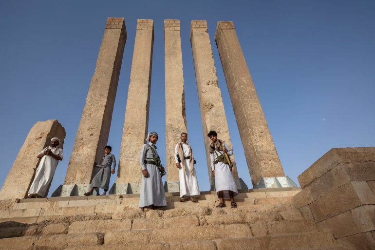 Armed men allied to Yemen's internationally recognized government pose for a photograph at Awwam Temple,
