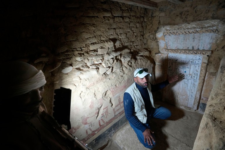 Mısırlı bir arkeolog, yakın zamanda keşfedilen ve Eski Krallık'a tarihlenen bir mezarın başında konuşuyor.