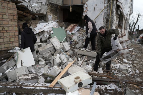 People pick up rubble after an attack in Ukraine
