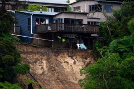 A landslide caused by floodwater undermines a house in Auckland, on January 28, 2023 [Hadyen Woodward/New Zealand Herald via AP]