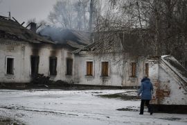 A resident walks past a school that was damaged by Russian shelling in the town of Orikhiv in the Zaporizhia region of Ukraine [Andriy Andriyenko/The Associated Press]