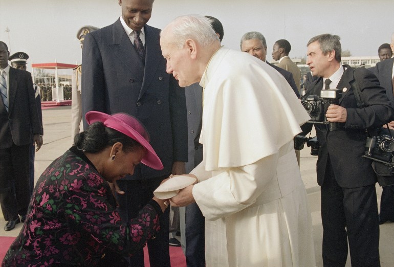 Pope John Paul II arrives at Dakar Airport in Senegal, West Africa, the first stop of his tour of African countries, Feb. 19, 1992. He is received by Muslim Senegalese President Abdou Diouf, center, and his Catholic wife, Elisabeth. (AP Photo/Santiago Lyon)
