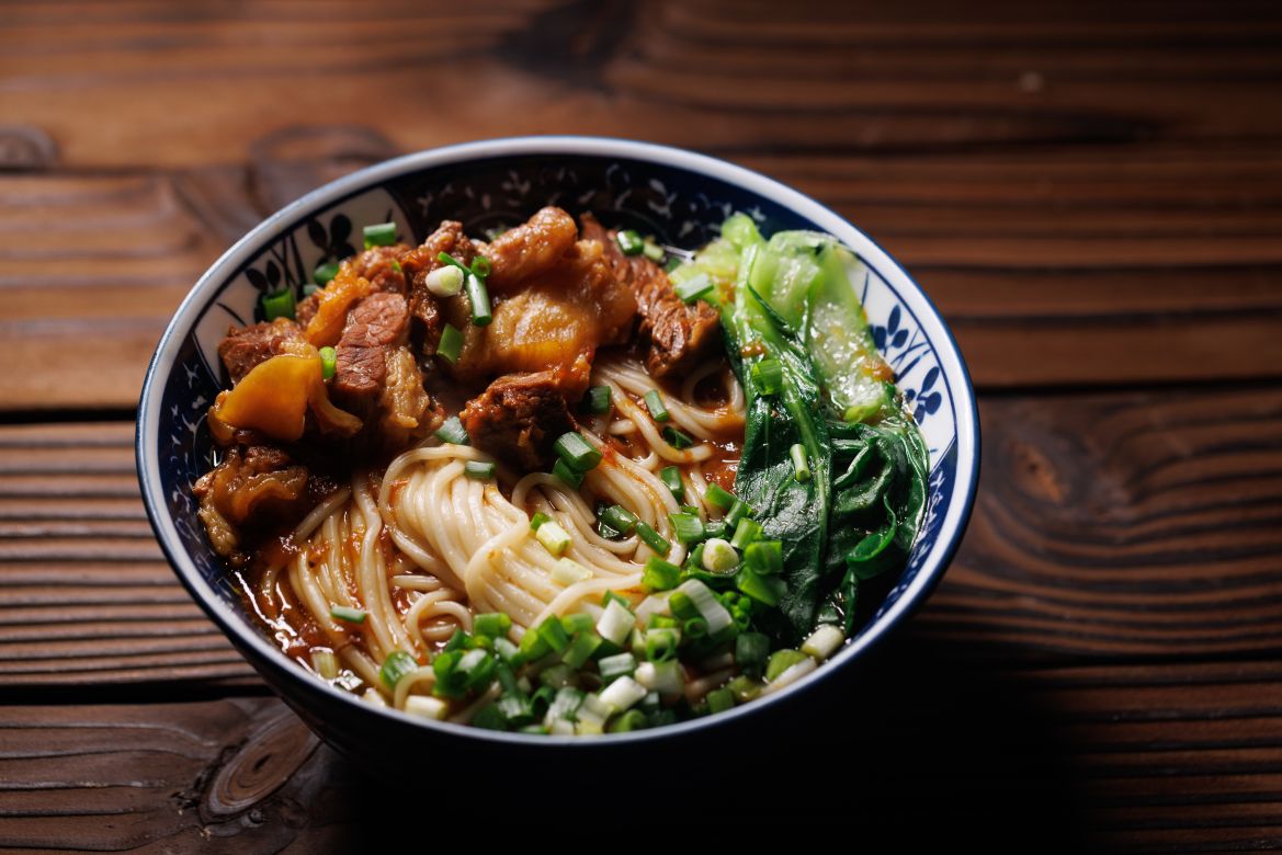 A bowl of noodles with beef and vegetables inside. It's a special Chinese food.