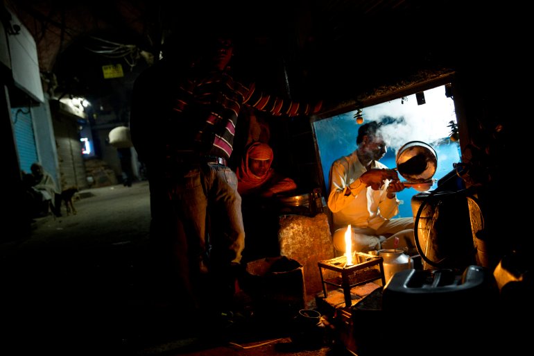 A tea seller prepares tea for laborers in the old city area of New Delhi, India