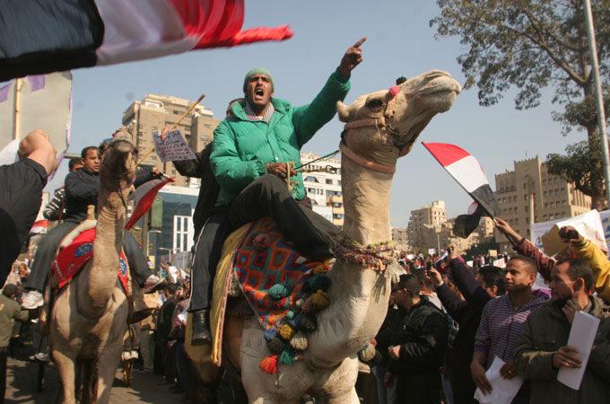 Supporters of embattled Egyptian president Hosni Mubarak ride camels and horses as they clash with anti-Mubarak protesters in Tahrir Square, Cairo, February 2, 2011. MICHEL MARCIPONT / GETTY IMAGES