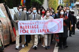 Plaintiffs and their supporters near the Tokyo District Court in Tokyo on November 30, 2022, in a lawsuit filed by same-sex couples [File: Kazuhiro Nogi/AFP]