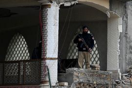 A policeman stands guard at a mosque damaged in a January 30, 2023, suicide blast inside police headquarters in Peshawar, Pakistan [Abdul Majeed/AFP]