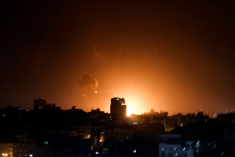 Fire and smoke rise above buildings in Gaza City as Israel launched air strikes on the Palestinian enclave early on February 2