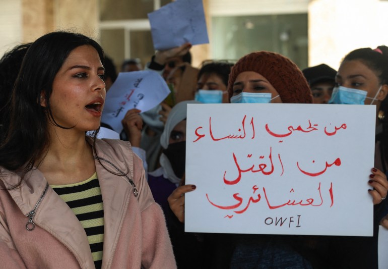 Iraqi women's rights activists hold up placards