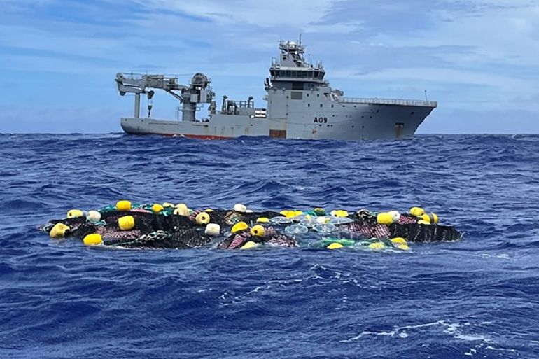 Packets of cocaine floating in netting in the Pacific. There is a ship from the New Zealand navy behind