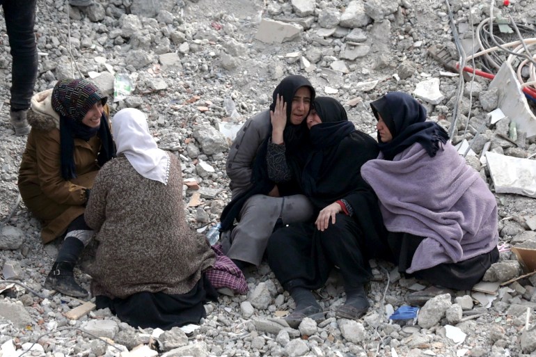 People react at the site of a collapsed building 