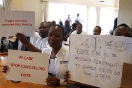 Senior doctors at Parirenyatwa General Hospital, Zimbabwe&#39;s biggest medical centre, hold placards protesting against a shortage of medicines, gloves and bandages in Harare, Zimbabwe on March 13, 2019 [Philimon Bulawayo/Reuters]