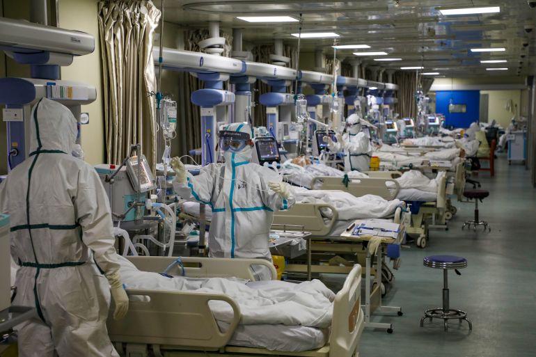 Medical workers in protective suits attend to COVID patients at the intensive care unit (ICU) of a designated hospital in Wuhan, Hubei province, China.