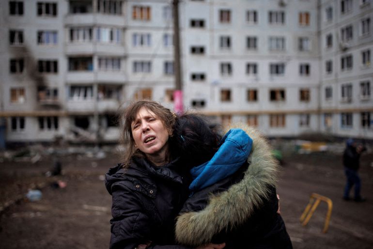 A woman reacts as she hugs another woman outside a heavily damaged apartment block, following an artillery attack, amid Russia's attack on Ukraine, in Kharkiv, Ukraine, April 13, 2022. REUTERS/Alkis Konstantinidis TPX IMAGES OF THE DAY