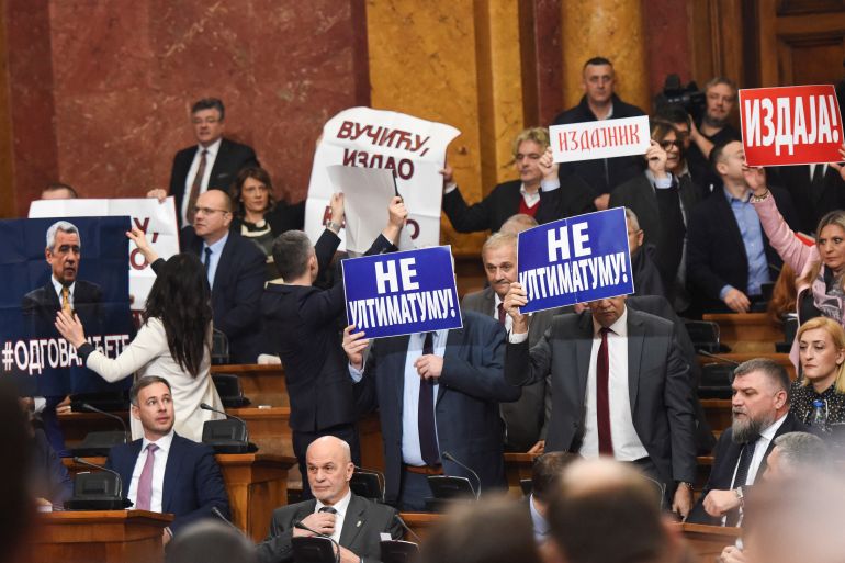 Lawmakers hold pictures of assassinated Kosovo Serb politician Oliver Ivanovic and banners that read: "Not to the ultimatum!" and "Vucic, betrayed Kosovo", during a special session of Serbia's parliament about the negotiating process with Kosovo in Belgrade, Serbia, February 2, 2023. REUTERS/Zorana Jevtic.