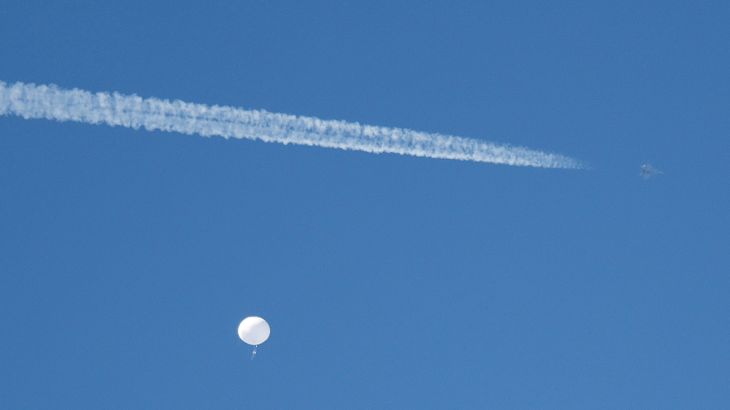 A jet flies by a suspected Chinese spy balloon as it floats off the coast in Surfside Beach, South Carolina