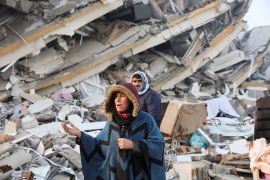 A woman reacts while standing amid rubble, following an earthquake in Hatay, Turkey, February 7, 2023 [Umit Bektas/Reuters]