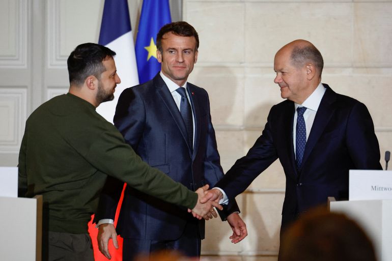 Ukraine's President Volodymyr Zelenskiy and German Chancellor Olaf Scholz shake hands during a joint statement with French President Emmanuel Macron, at the Elysee Palace in Paris, France.