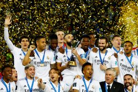 Real Madrid's Karim Benzema kisses the trophy and celebrates with teammates