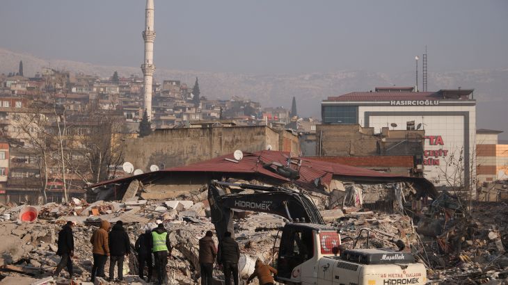 People stand amid rubble and damages, in the aftermath of a deadly earthquake in Kahramanmaras, Turkey February 12, 2023.