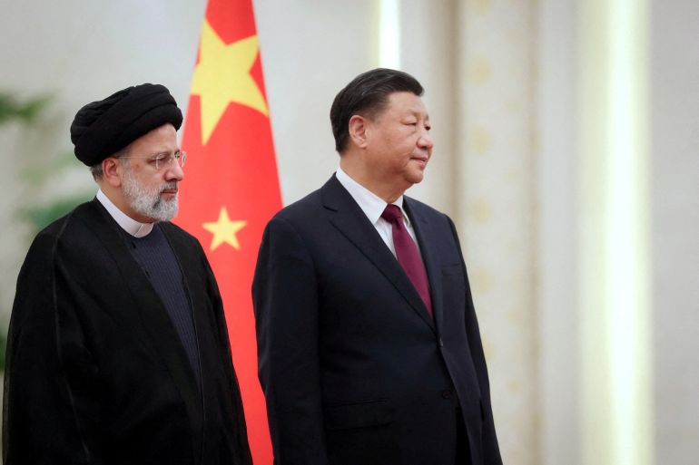 Iranian President Ebrahim Raisi stands next to Chinese President Xi Jinping during a welcoming ceremony in Beijing