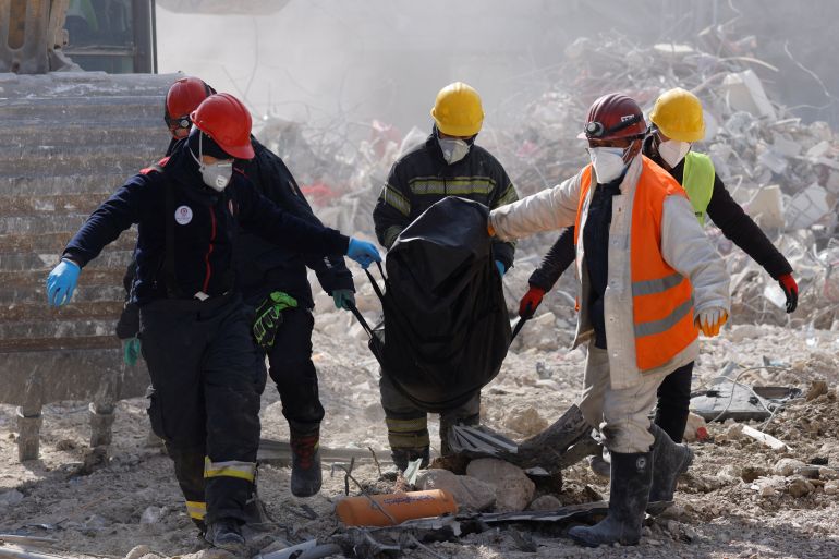 Rescuers carry a body of a victim of a deadly earthquake in Antakya