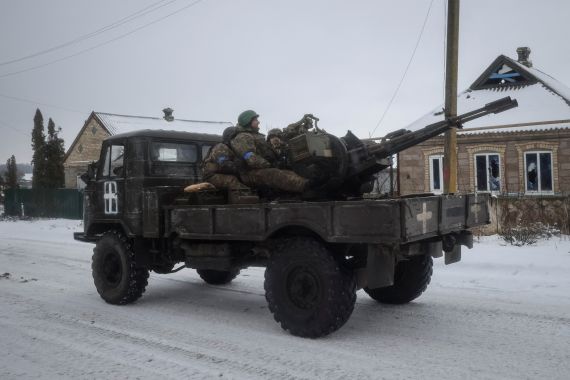 Ukrainian service members ride on a military vehicle with a ZU-23-2 anti-aircraft cannon in the front-line city of Vuhledar, Ukraine.