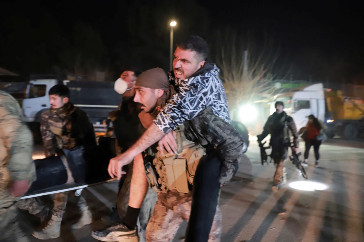 A member of Turkish police special forces carries a wounded man in Hatay province.