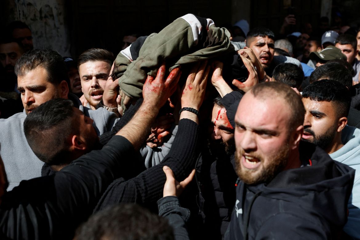 Mourners carry the body of a Palestinian fighter who was killed by Israeli troops