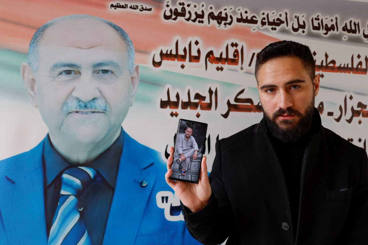 Palestinian nurse Elias al-Ashkar holds a picture of his father