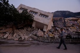 FILE PHOTO: FILE PHOTO: A man walks by a collapsed building and rubble, in the aftermath of a deadly earthquake, in Antakya, Hatay province, Turkey, February 21, 2023. REUTERS/Clodagh Kilcoyne/File Photo/File Photo