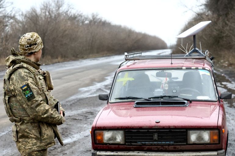 A Ukrainian serviceman stands next to a vehicle that carries a Starlink satellite internet system near the frontline in Donetsk region