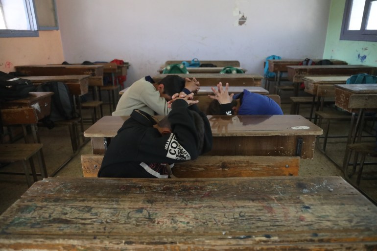 Students at Harem Boys School adopt the brace position in an evacuation drill designed for future earthquakes