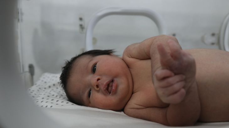 Baby Aya looks out of the incubator at the photographer
