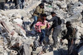 A man carries the body a child pulled out from the rubble in the town of Harim, in Syria&#39;s Idlib province [Mohammed Al-Rifai/AFP]