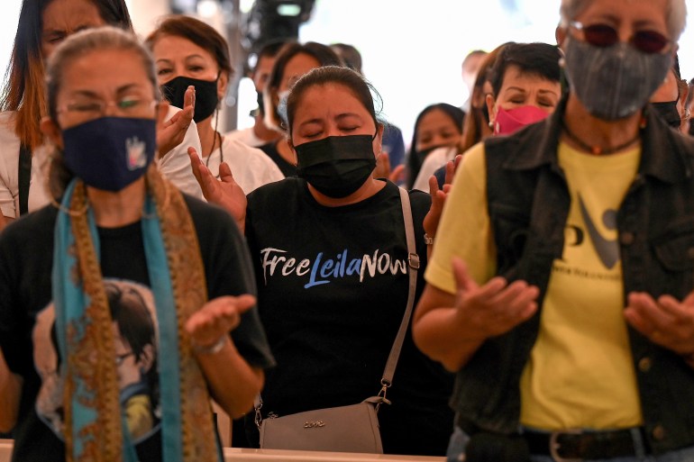 Leila de Lima's supporters attend a mass calling for her release on February 17. One is wearing a black t-shirt reading 'Free Leila Now'. They have their hands out in prayer.