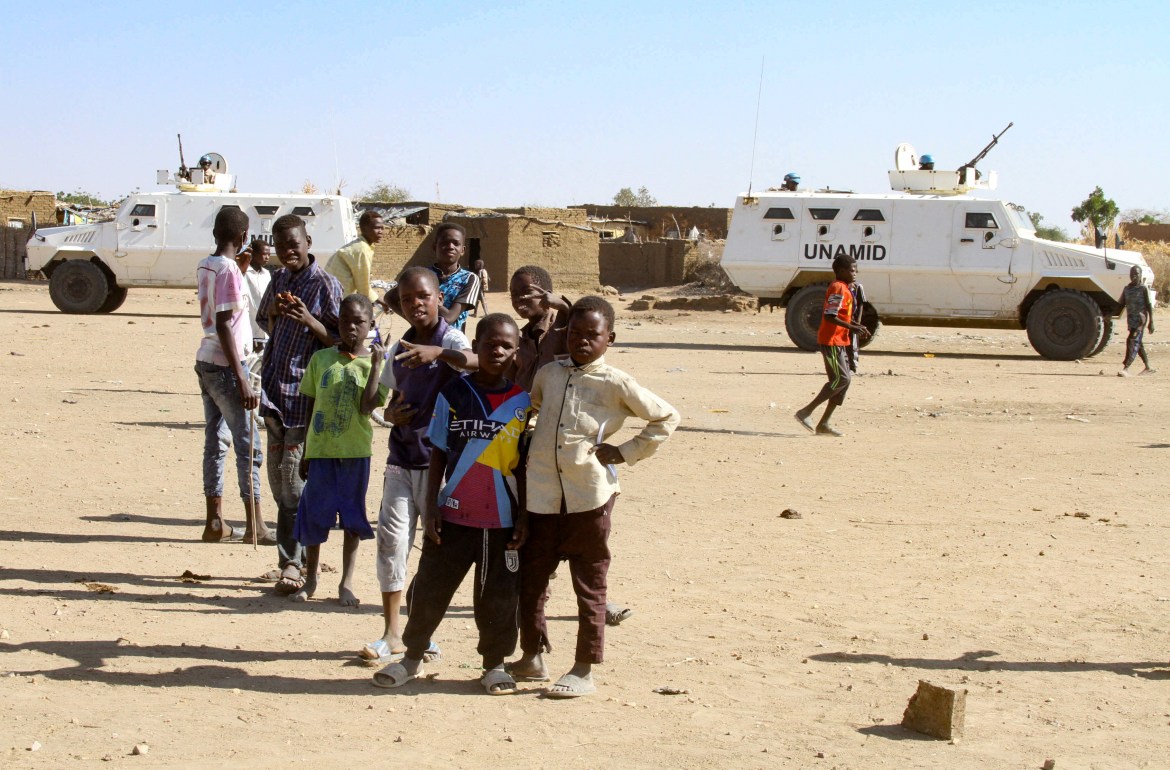 Sudanese children gather in front of an armoured vehicle