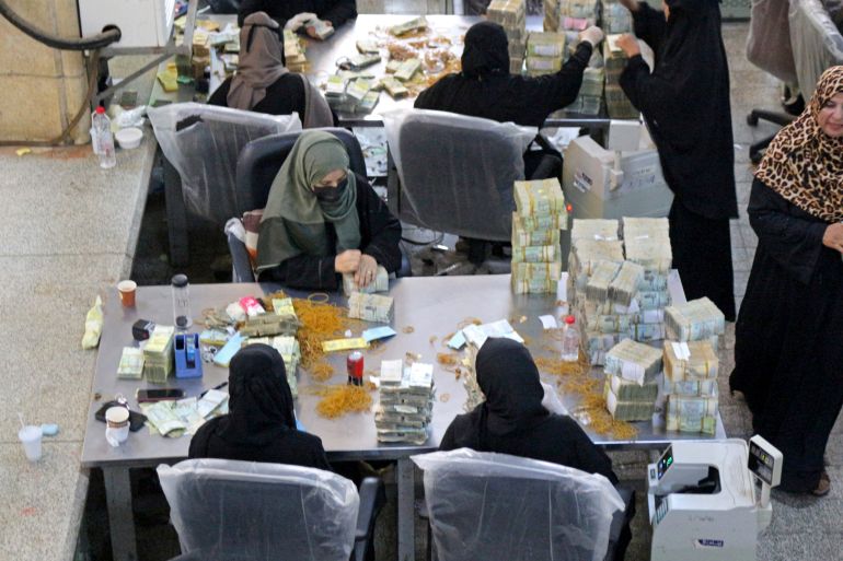 Employees count stacks of Yemeni currency at the central bank in the southern port city of Aden on September 28, 2021. - Subject to the world's worst humanitarian crisis according to the UN, Yemen's economic woes stem from the seven-year conflict between Huthi rebels controlling most of the country's north and government forces holding the south. (Photo by Saleh Al-OBEIDI / AFP)