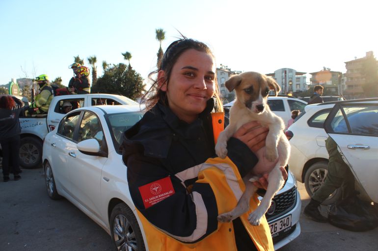 A Turkish health worker brings a puppy to the field hopsital in Antakya