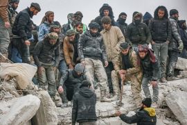 Personnel and civilians conduct search and rescue operations in Idlib