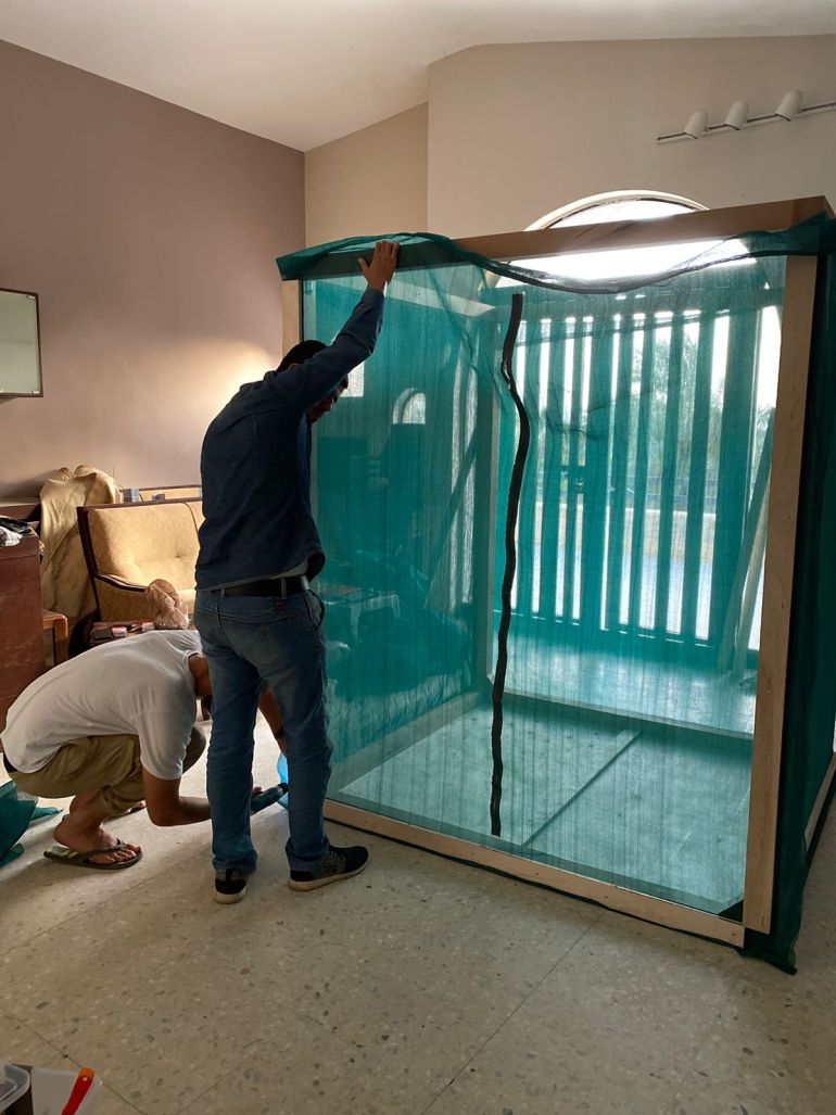 Two men building a soundproof booth