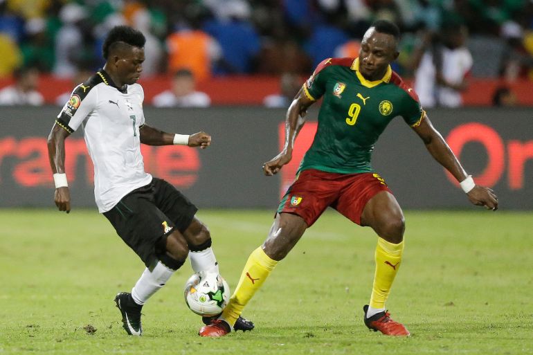 Ghana's Christian Atsu, left, is challenged by Cameroon's Zoua Daogari Jacques, right, during the African Cup of Nations semifinal soccer match between Cameroon and Ghana