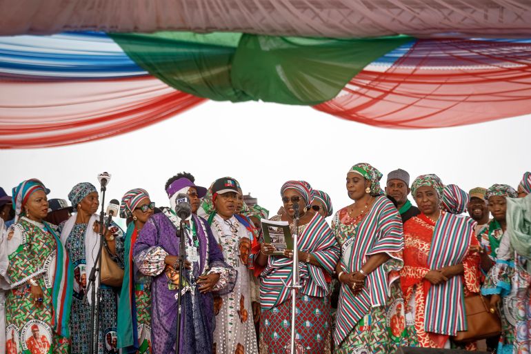 Women party members and officials take the stage to speak at a rally of the ruling All Progressives Congress