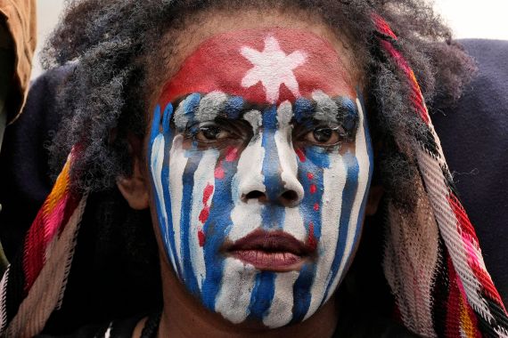 A close up of a Papuan student at a demonstration in Jakarta. The have painted their face in the red, white and blue of the independence movement's 'Morning Star' flag