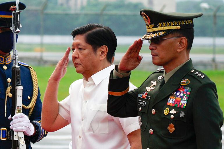 Philippine President Ferdinand Marcos Jr. salutes with Philippine military chief Lt. Gen. Bartolome Vicente Bacarro before departing to Beijing on Jan. 3, 2023, at the Villamor Air Base in Metro Manila, Philippines. Marcos Jr. on Saturday Jan. 7 cut short the term of Lt. Gen Bacarro, whom he appointed five months ago, and replaced him with a retiring general without explaining the surprise move. (AP Photo/Aaron Favila, File)
