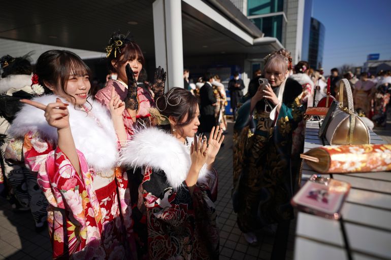 Young Japanese women celebrate 'Coming of Age Day'. They are wearing kimonos and laughing.